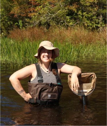 woman standing in a pond with a net